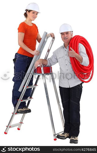 female plumber on ladder with male tutor