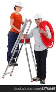 female plumber on ladder with male tutor