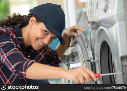 female plumber repairing washing machine