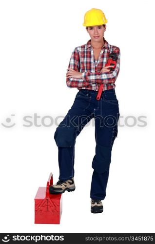 Female plumber standing on white background