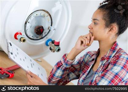 female plumber trying to figure out the boiler problem