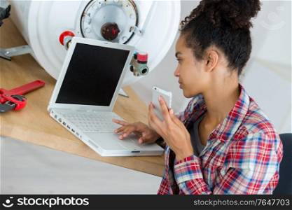 female plumber using a laptop at work