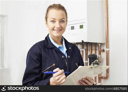 Female Plumber Working On Central Heating Boiler