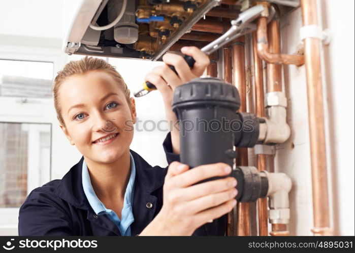 Female Plumber Working On Central Heating Boiler