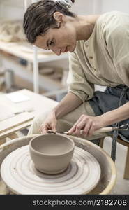 Female potter modeling clay bowl in workshop - Artisan work and creative craft concept