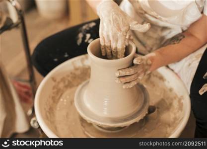 female potter s hand making ceramic pot with clay pottery wheel