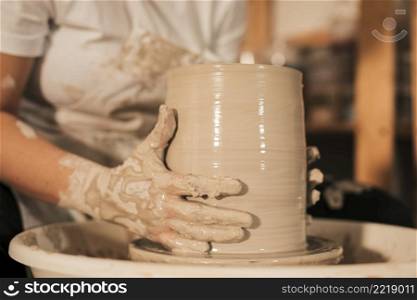 female potter shaping pot pottery workshop