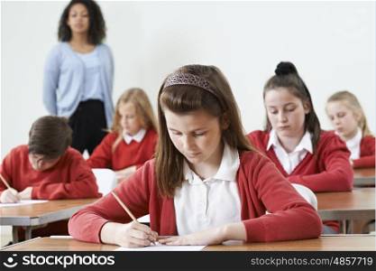 Female Pupil At Desk Taking School Exam