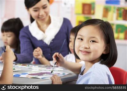 Female Pupil Enjoying Art Class In Chinese School Classroom