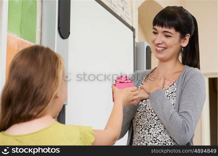 Female Pupil Giving Teacher End Of Term Gift