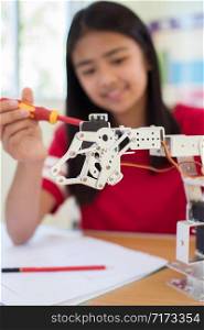 Female Pupil In Science Lesson Studying Robotics