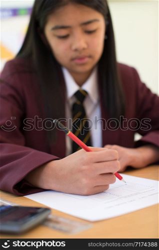 Female Pupil In Uniform Taking Multiple Choice Examination Paper