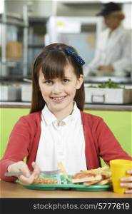Female Pupil Sitting At Table In School Cafeteria Eating Unhealthy Lunch