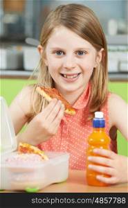 Female Pupil Sitting At Table In School Cafeteria Eating Unhealthy Packed Lunch