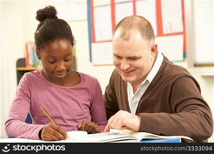 Female Pupil Studying in classroom with teacher