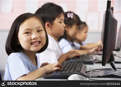 Female Pupil Using Keyboard During Computer Class In Chinese School Classroom