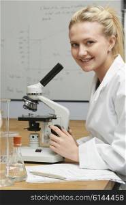 Female Pupil Using Microscope In Science Lesson