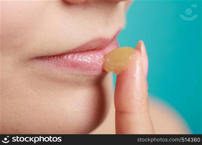Female putting applying lip balm moisturizing balsam. Girl taking care of lips. Skincare.. woman applying balsam for lips