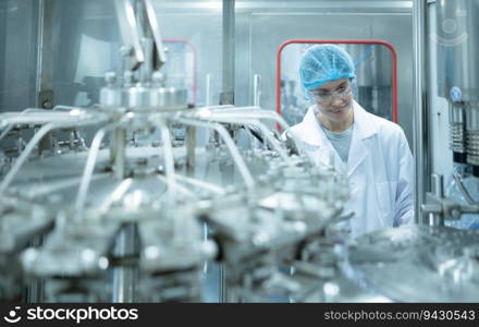 Female quality control worker inspecting water bottle on production line in drinking water factory