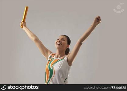 Female relay runner celebrating victory isolated over gray background