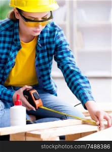 Female repairman carpenter cutting joining wooden planks doing renovation. Female repairman carpenter cutting joining wooden planks doing r