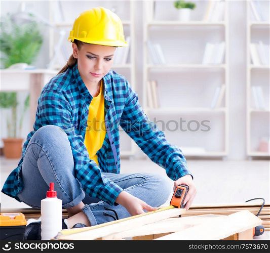 Female repairman carpenter cutting joining wooden planks doing renovation. Female repairman carpenter cutting joining wooden planks doing r
