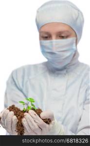 female researcher biologist holding soil in his hands and a green sprout on a white background
