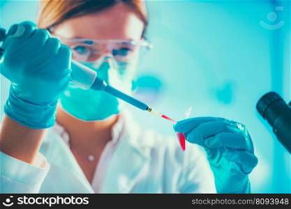 Female researcher using micro pipette