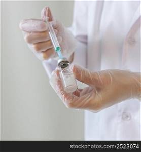 female researcher with gloves holding syringe
