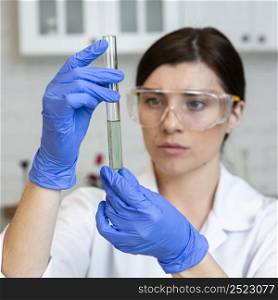 female researcher with safety glasses test tube