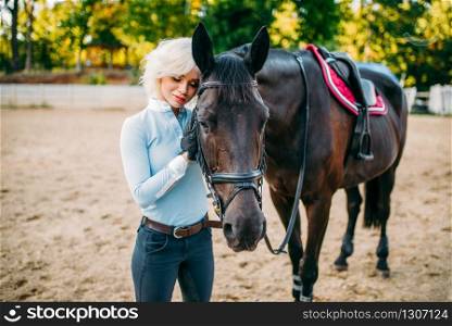 Female rider hugs her horse, friendship, horseback riding. Equestrian sport, young woman and beautiful stallion, farm animal. Female rider hugs her horse, horseback riding