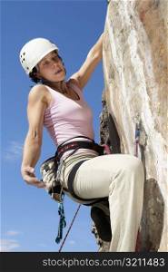 Female rock climber scaling a rock face