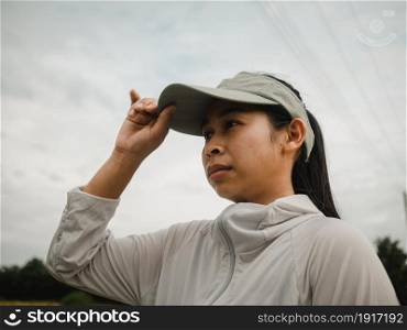 Female runners in a hat prepares for jogging outdoors. Athlete enjoying a morning of exercise. Healthy lifestyle concept.