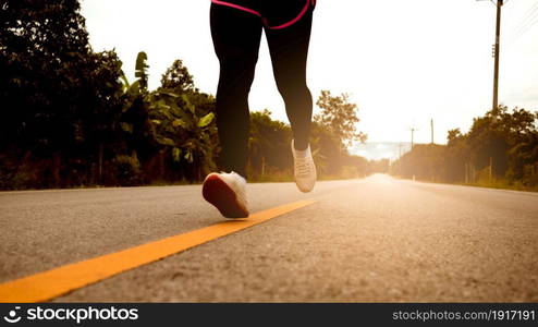 Female runners running on the road trail in morning training for marathon and fitness. Healthy lifestyle concept. Athlete running exercising outdoors. Close-up legs.