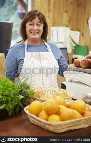 Female Sales Assistant At Checkout Of Farm Shop