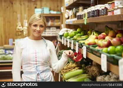 Female Sales Assistant At Vegetable Counter Of Farm Shop