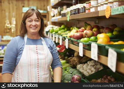 Female Sales Assistant At Vegetable Counter Of Farm Shop