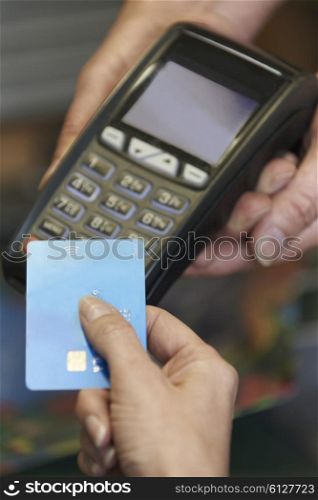 Female Sales Assistant Holding Credit Card Machine