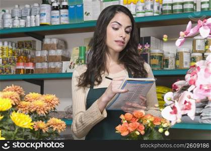 Female sales clerk checking an invoice in a flower shop