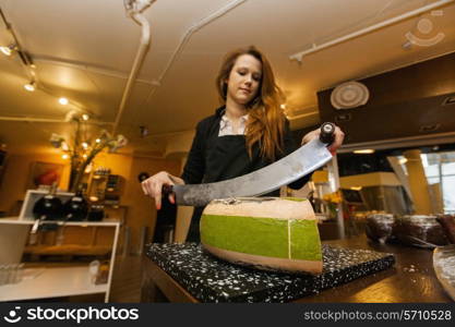 Female salesperson cutting cheese at store