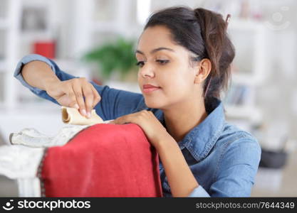 female sanding a chair in the workshop