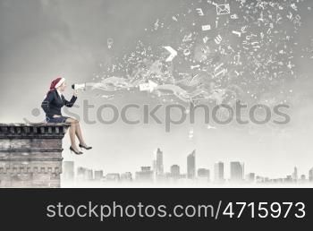 Female Santa making announcement. Woman in suit and Santa hat shouting into megaphone