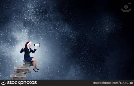 Female Santa making announcement. Woman in suit and Santa hat shouting into megaphone