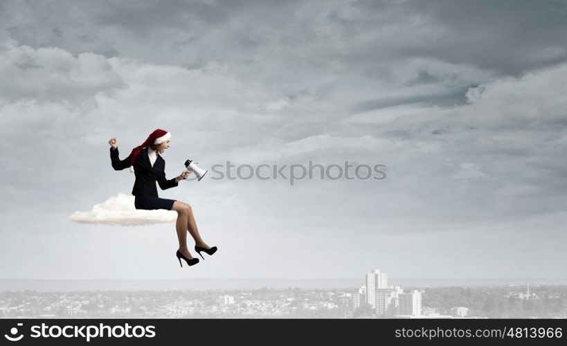 Female Santa with megaphone. Woman in suit and Santa hat shouting into megaphone