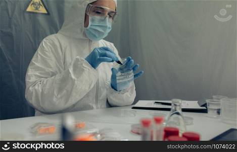 Female scientist analyzing samples contaminated with virus in a laboratory. Scientist analyzing samples contaminated with virus