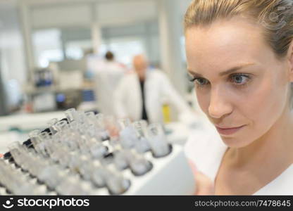 female scientist examining chemical sample in test tube in lab