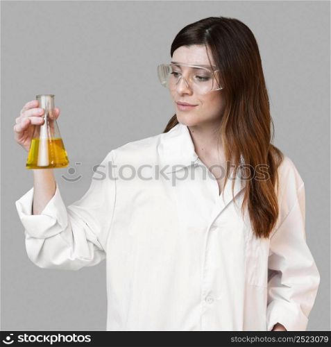 female scientist holding test tube while wearing safety glasses