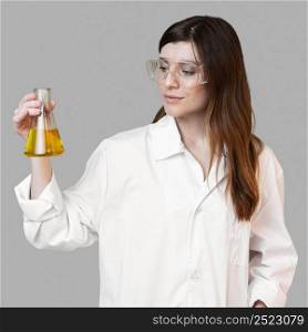 female scientist holding test tube while wearing safety glasses