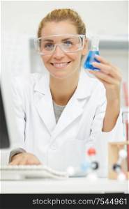 female scientist holding test tube with sample making research