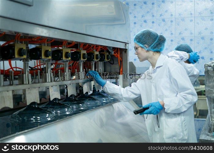 Female scientist in white coat and blue hat working in the control  machine of production line.